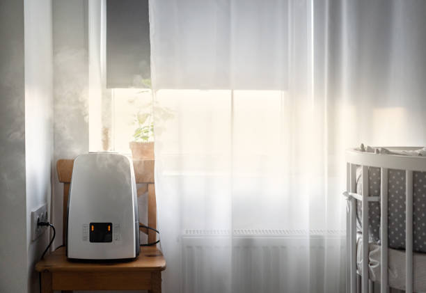 humidificador de aire moderno cerca de la ventana en la habitación de los niños. purificación del aire y salud. - humidifier steam home interior appliance fotografías e imágenes de stock