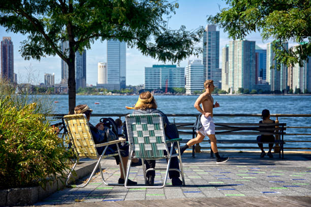 kobiety relaksujące się wzdłuż nabrzeża hudson river park, dolny manhattan, nowy jork, stany zjednoczone ameryki - editorial shadow new york city manhattan zdjęcia i obrazy z banku zdjęć