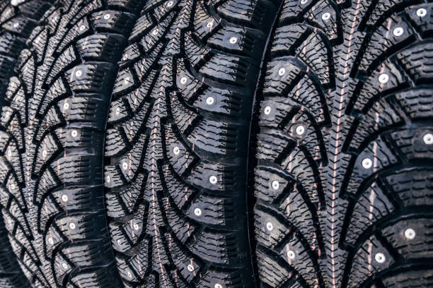 clean new modern studded winter tires in row. tires with spikes, close up - truck wheel car macro imagens e fotografias de stock