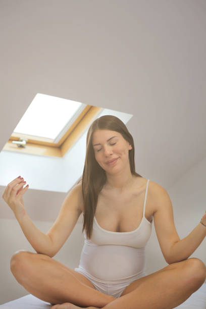 istock Pregnant woman meditating on bed. 1090236642