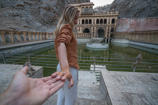 Follow me to monkey temple, India. Female tourist leading boyfriend to the sacred place. People travel concept
