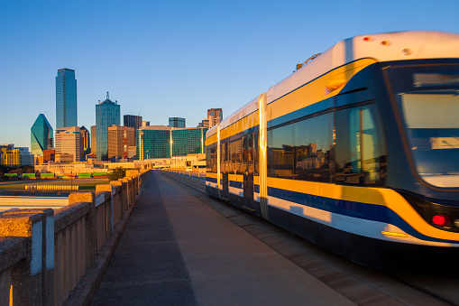 Moving streetcar on the Houston Street Viaduct with the city of Dallas in background