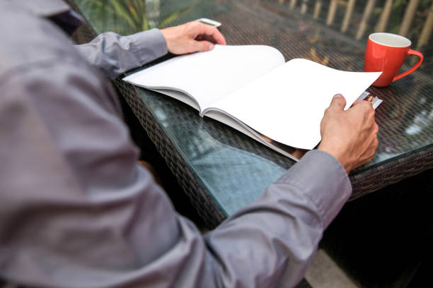 Close up business man reading a magazine in the outdoor table