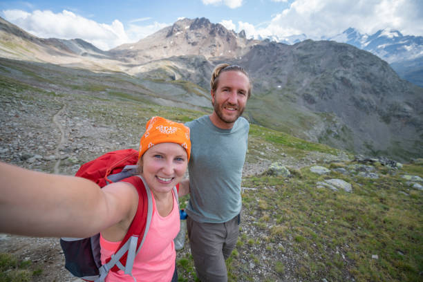 istock Young couple taking a selfie portrait while hiking on mountain trail 1090247158