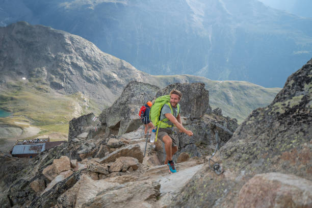istock Two climbers making their way to the top gripping rocks and chains to mountain summit 1090247214