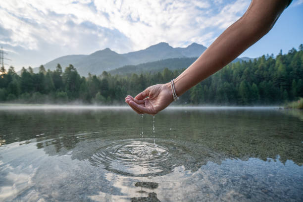 human hand cupped to catch fresh water from mountain lake, switzerland - mountain drop europe switzerland imagens e fotografias de stock