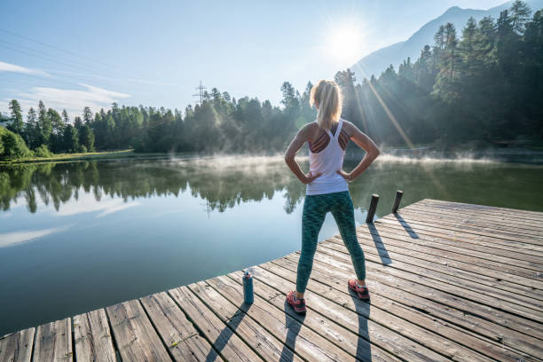 Young woman stretching body on morning jogging, sunrise over beautiful peaceful lake in nature, female standing on pier over water Young woman stretching body before morning jogging, sunrise over beautiful peaceful lake in nature, female standing on pier over water
Shot in Graubunden Canton, Switzerland. behavior femininity outdoors horizontal stock pictures, royalty-free photos & images