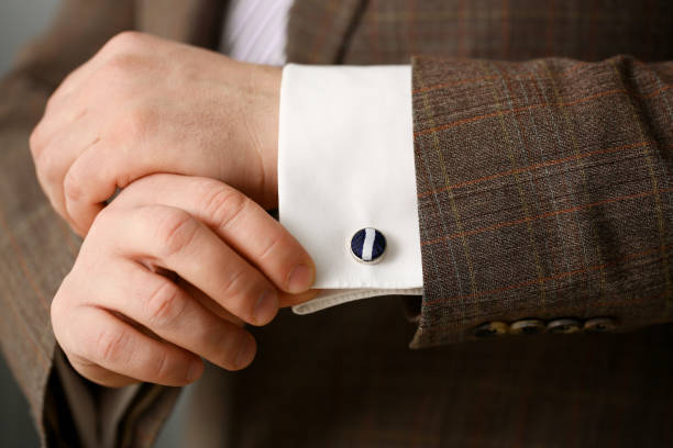 istock Male arm in brown suit set stud closeup 1090262478
