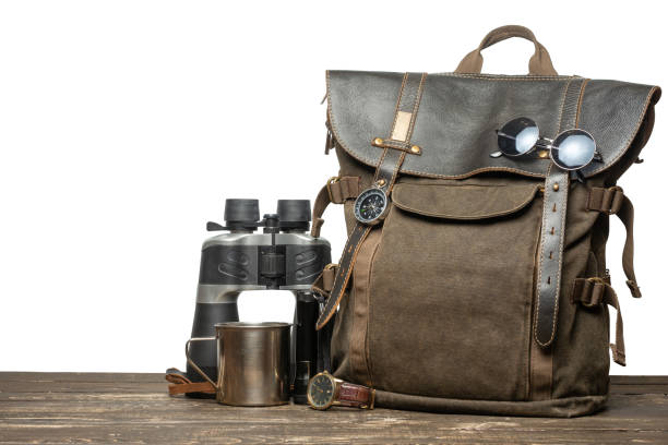 istock Vintage brown backpack with tourism accessories on a table with an isolated background. 1090270820