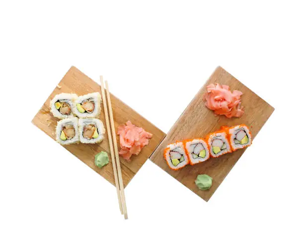 Assorted Sushi Maki Rolls containing Avocado, Crab, Tempura Prawns and Kobiko/Roe; With Wasabi, Pickled Ginger and Chopsticks; Isolated on White Background.