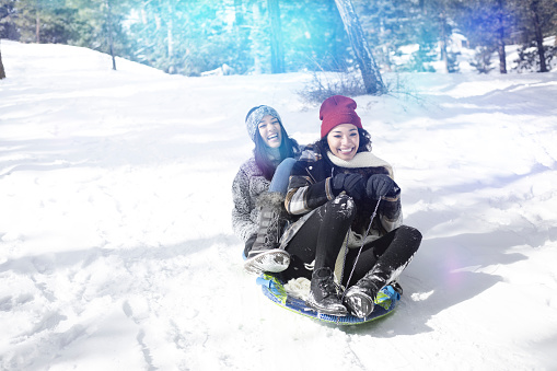Two woman on a winter vacations playing in the snow.