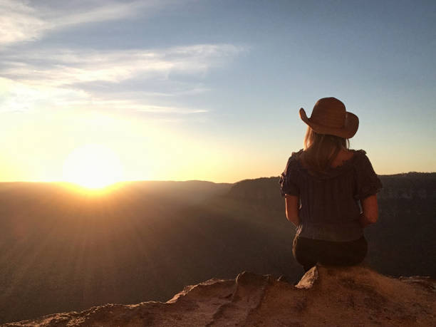 istock Woman in mountain cave watching sunset over bushland 1090322866