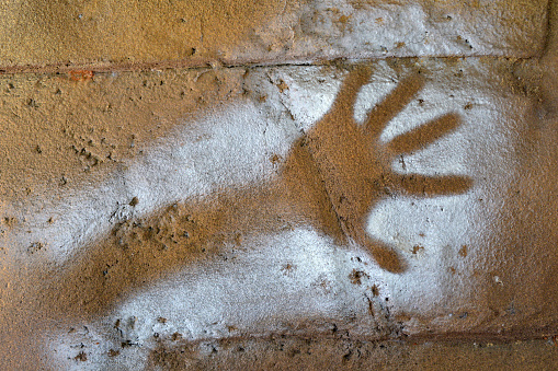 Painted handprint stenciled on a rock