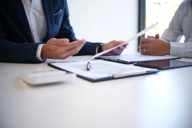 Sales manager giving advice application form document, considering mortgage loan offer for car and house insurance. Sales manager giving advice application form document, considering mortgage loan offer for car and house insurance legal insunace stock pictures, royalty-free photos & images
