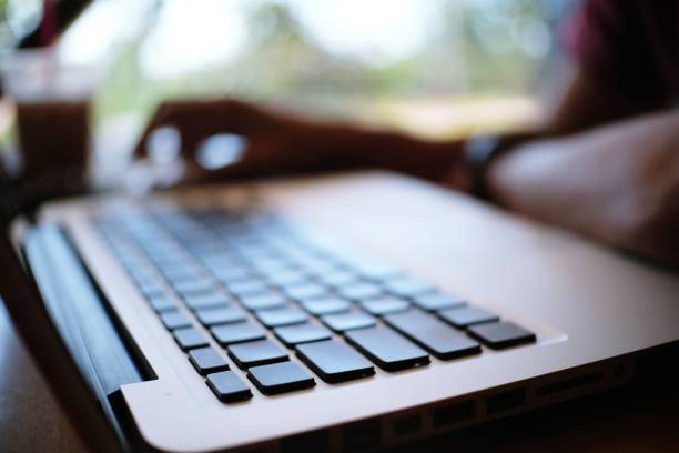 istock Man working by using a laptop computer on wooden table. Hands typing on a keyboard 1090348694