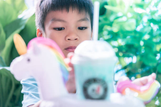 istock Little asian boy is drinking Unicorn milk 1090350624