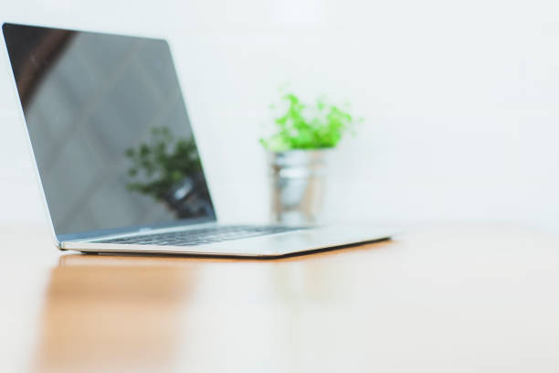 istock laptop on brown wooden top table, with white background, Blank copy space for Product display. 1090350794