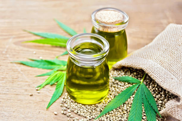 istock Oil hemp in two jars with green sheet on board 1090370094