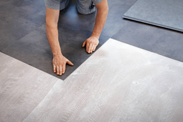 worker making vinyl flooring - tile adhesive imagens e fotografias de stock