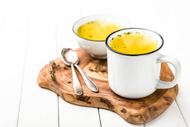 homemade simple soup in a white cup against colds - caldo imagens e fotografias de stock