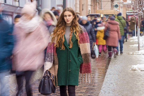 focused woman among the crowd focused woman among moving blurred crowd in winter defocused woman stock pictures, royalty-free photos & images