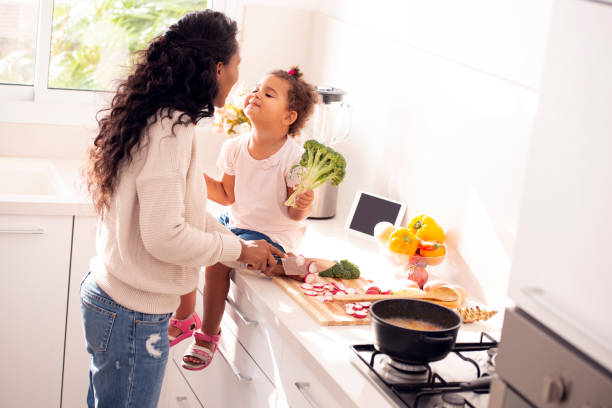 istock Daughter kissing her mother while the mum cooking. 1090393574