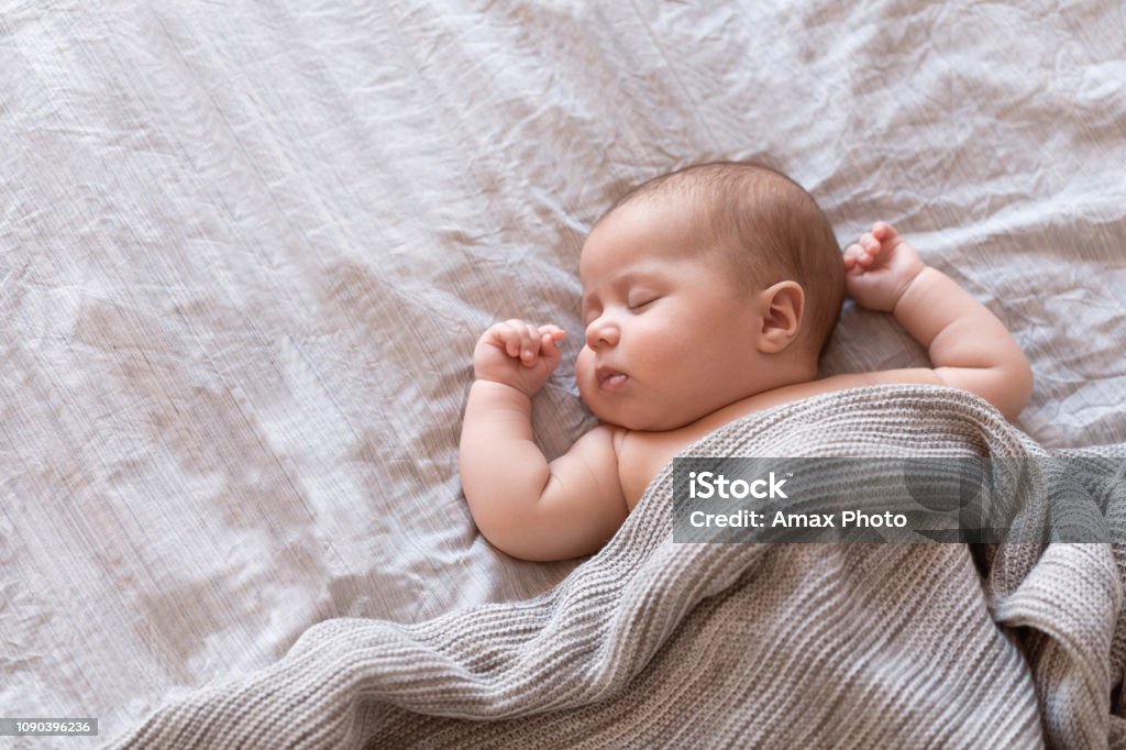 Friedliche Babys auf einem Bett liegen und schlafen zu Hause - Lizenzfrei Baby Stock-Foto