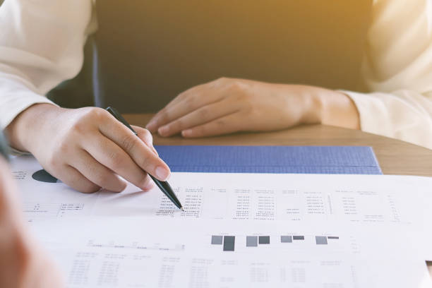 istock Businesswoman analyzing investment charts and pressing calculator buttons over documents. Accounting Concept. 1090401088