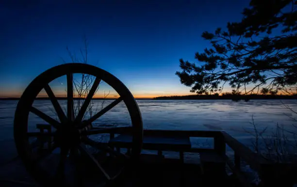 A star shining through a wooden wheel, frozen lake in Finland.