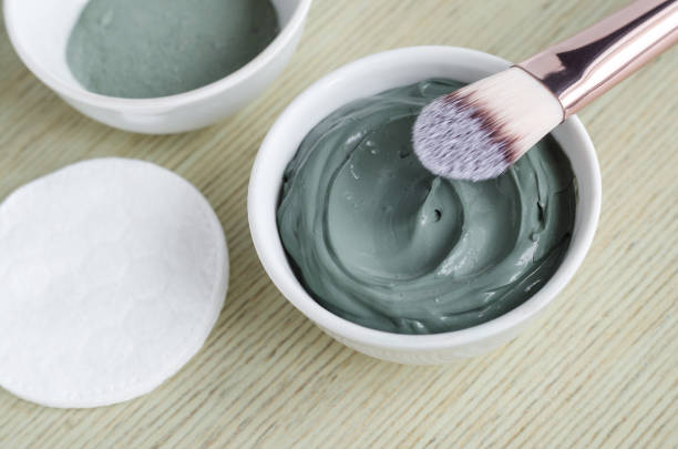 Small white bowl with blue cosmetic clay mask. Homemade beauty treatments. Copy space. Small white bowl with blue cosmetic clay mask. Homemade beauty treatments. Copy space. green clay stock pictures, royalty-free photos & images