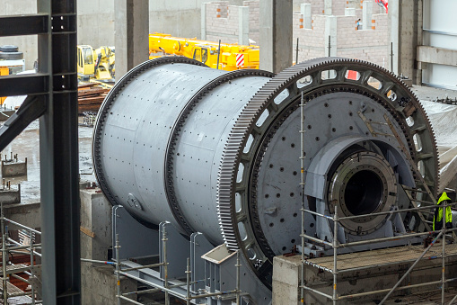 Close up view of the large ball and sag mill in the mine plant. A typical type of fine grinder is the ball mill. A slightly inclined or horizontal rotating cylinder is partially filled with balls.