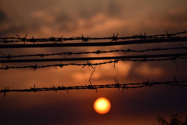SUNSET SUNSET BEHIND BARBED WIRE south sudan stock pictures, royalty-free photos & images