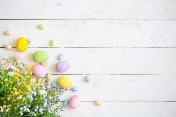 istock Easter eggs with flowers on white rustic wooden background. View from above 1090418652