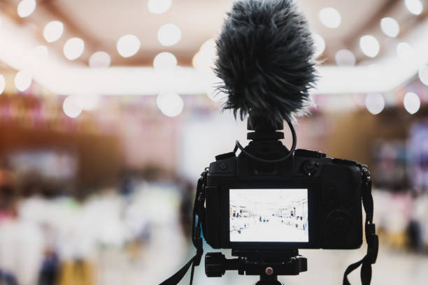 istock Video or professional digital mirrorless on tripod for camera recording with microphone taking photograp in wedding convention hall in live streaming event, seminar production equipment. 1090425410