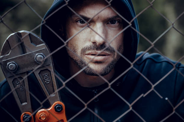 Thief Thief with bolt cutter behind the fence bolt cutter stock pictures, royalty-free photos & images