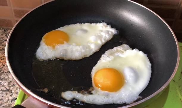 imagem de ovos fritos em frigideira antiaderente com óleo de cozinha - non stick - fotografias e filmes do acervo