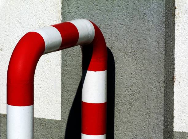 A frozen white and red bollard preventing the passage of motor vehicles in the settlement
