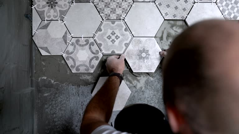 Builder placing tiles on the floor