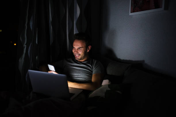 istock Man sitting on the sofa with a mobile phone and computer 1090449514