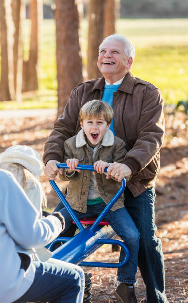 istock Boy with grandfather on seesaw at playground 1090452464