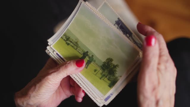 Elderly woman holding old photo of her husband