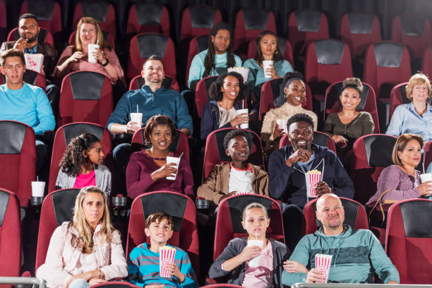 istock Multi-ethnic audience watching movie in theater 1090457438