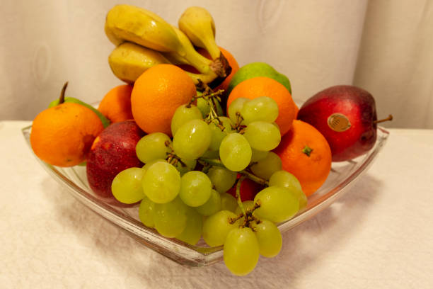 Glass bowl standing on a table filled with different fruits, picture from Northern Sweden.
