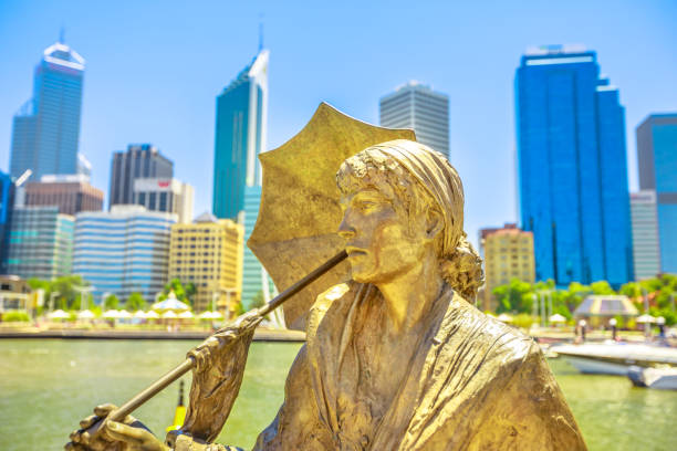 Perth, Western Australia - Jan 3, 2018: Bessie Rischbieth Statue by artist Jon Tarry at Elizabeth Quay on the Swan River. Skyscrapers of Central Business District on background. Blue sky summer season