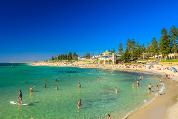 Cottesloe Beach Perth Cottesloe, Western Australia - Jan 2, 2018: white sand, calm turquoise waters for snorkeling at Cottesloe, Perth's most famous beach, Indian Ocean. Cottesloe Surf Lifesaving Club on background cottesloe beach stock pictures, royalty-free photos & images