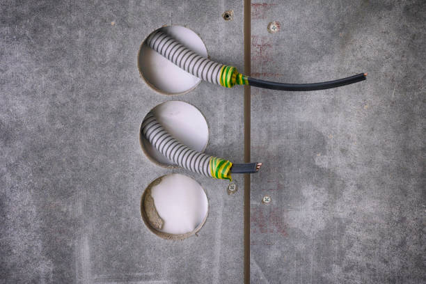 Plastic corrugated pipes with electric cable inside sticking out of wall for power sockets. Close-up.