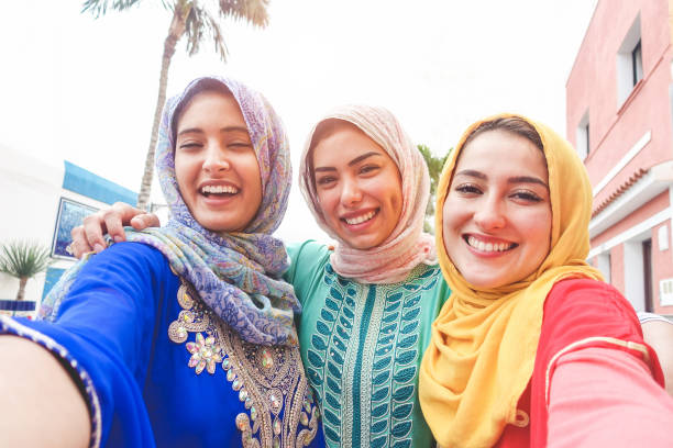 Islamic young friends taking selfie with smartphone camera outdoor - Happy arabian girls having fun with new trend technology - Friendship and millennial app concept - Focus on faces Islamic young friends taking selfie with smartphone camera outdoor - Happy arabian girls having fun with new trend technology - Friendship and millennial app concept - Focus on faces moroccan woman stock pictures, royalty-free photos & images