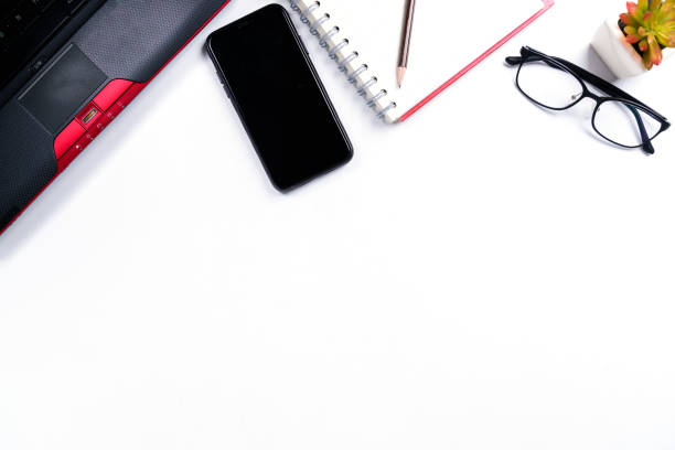 istock Top view or Flat lay style with copy space of workspace with laptop , pen , notebook , eyeglasses and mobile phone on white table background or isolated 1090488188