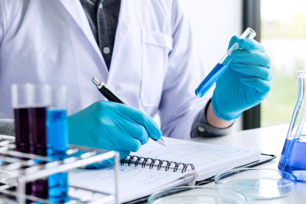 istock Biochemistry laboratory research, Chemist is analyzing sample and record in laboratory with equipment and science experiments glassware containing chemical liquid 1090490072
