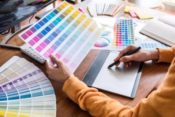 istock Image of female creative graphic designer working on color selection and drawing on graphics tablet at workplace with work tools and accessories 1090490112